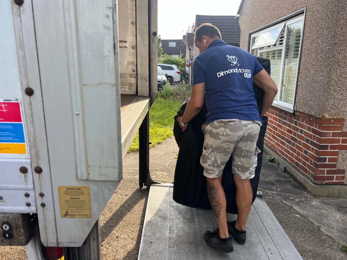 Dimond Movers crew loading a wrapped piano up the truck tail-lift