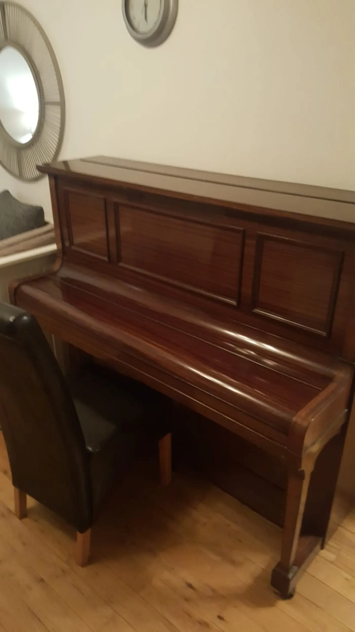 Polished mahogany upright piano ready to be moved by Dimond Movers