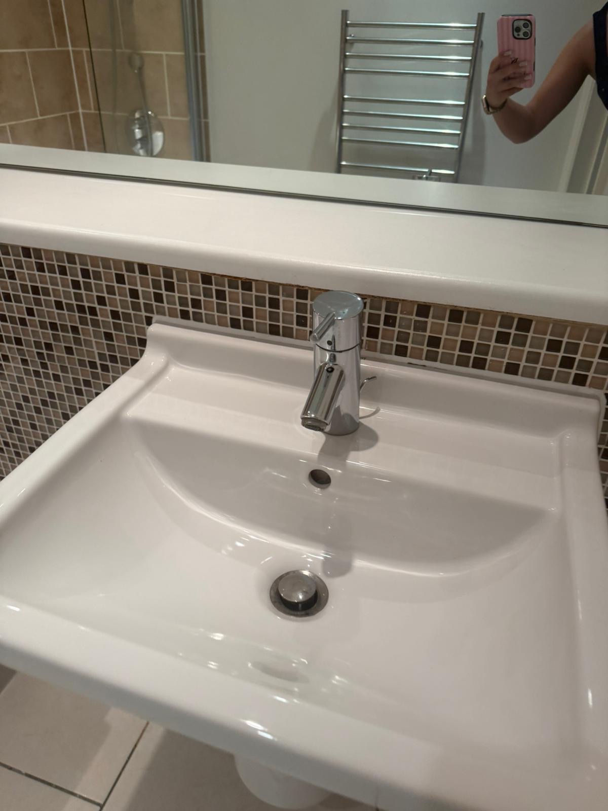 Polished bathroom basin and chrome tap after deep clean