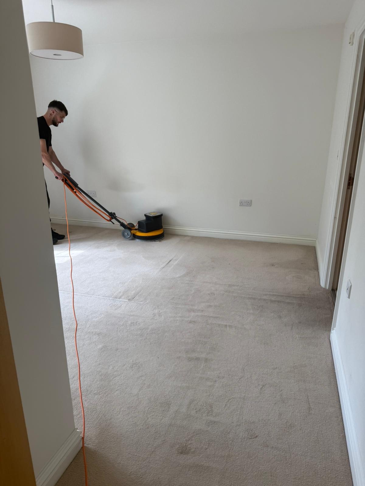 Professional carpet cleaning in progress with rotary machine