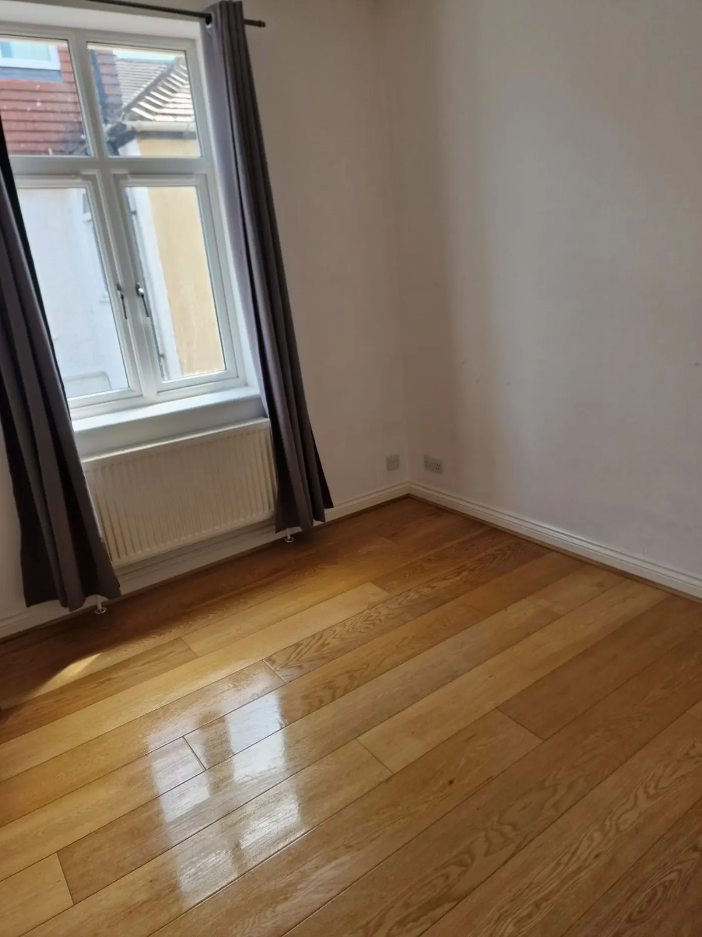 Empty bedroom with polished oak floor and clean skirtings after end of tenancy clean