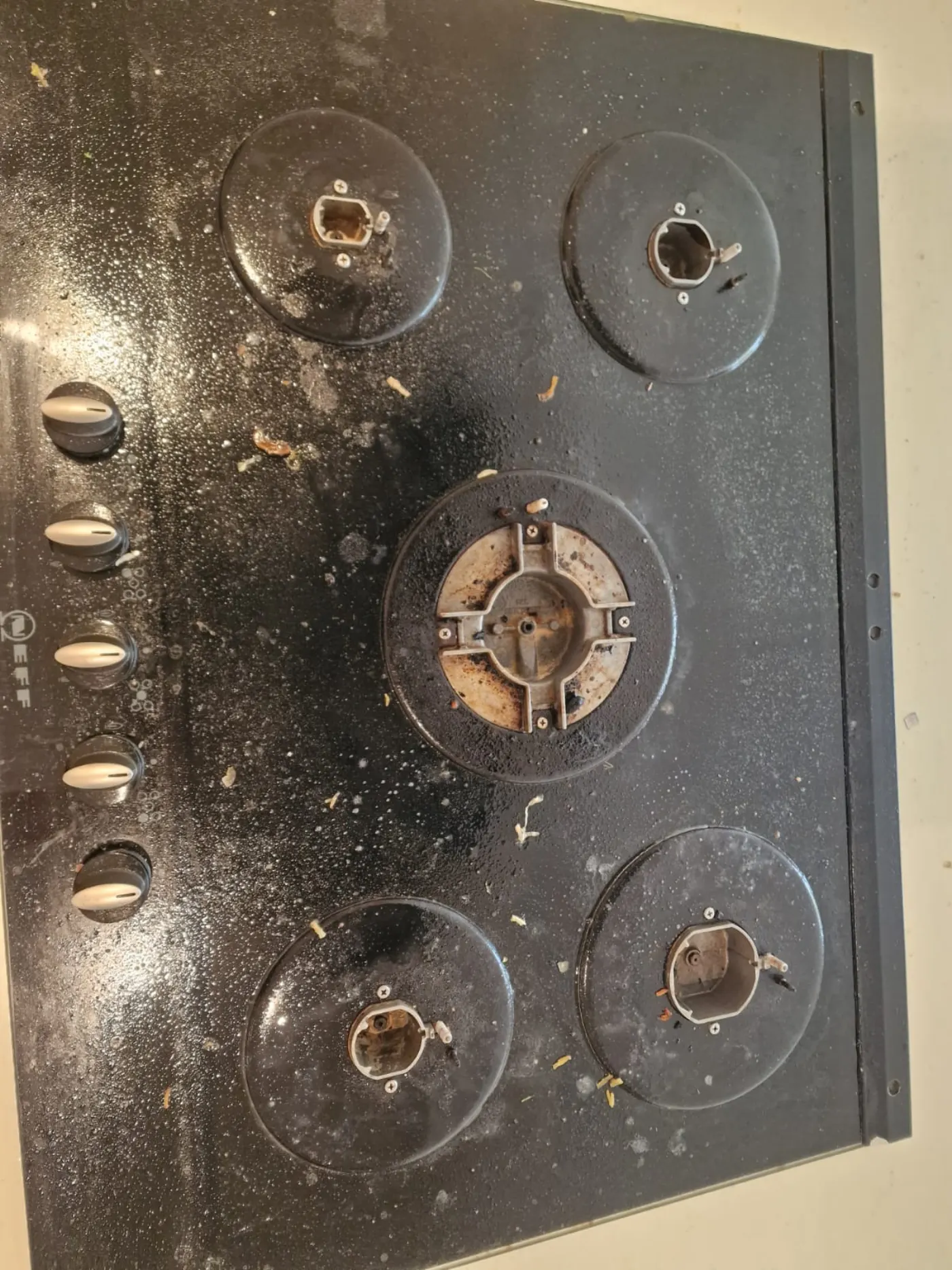 Heavily soiled Neff gas hob before Dimond Movers deep clean — burnt-on grease and food debris