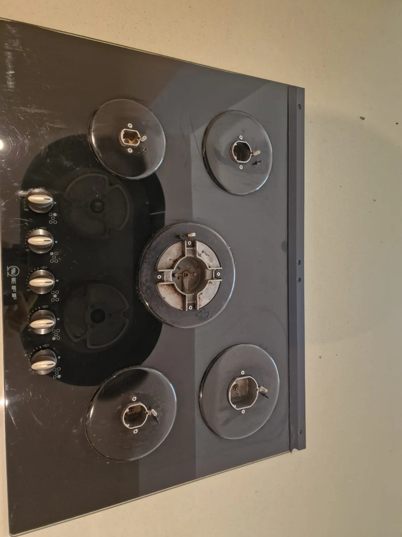 Same Neff hob mid-clean — grease lifted, glass cleared and burners stripped